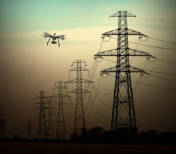 Power transmission in black colour, cyberone drone is flying over it.